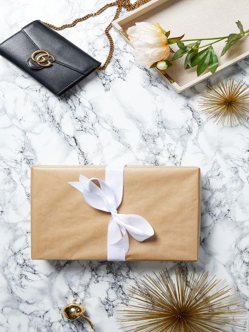 cadeau pour votre sœur un cadeau emballe dans du papier kraft et un petit sac noir elegant pose a cote