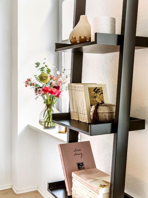 petite-piece Etagère noire contre mur avec livres et plantes
