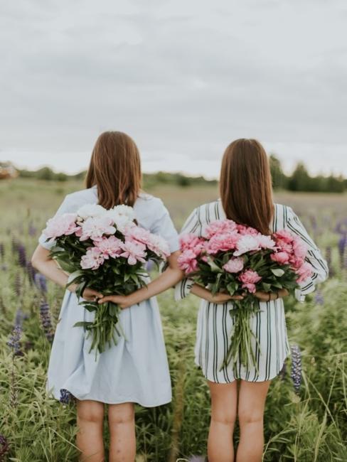 Meilleures amies deux jeunes femmes dans les champs avec un bouquet de fleurs