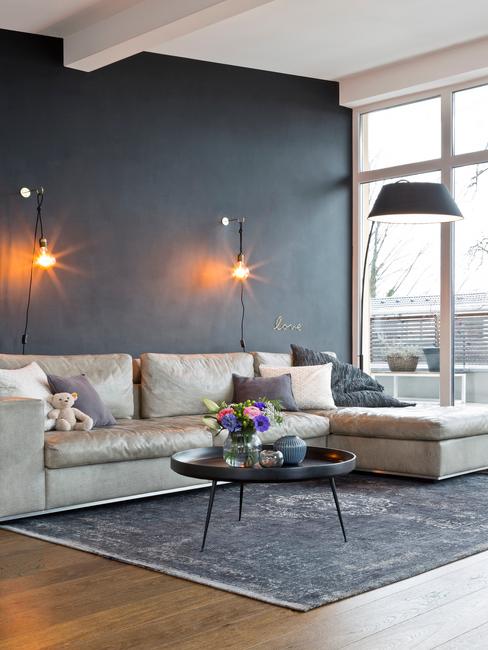 Westwing_Homestrory-Tobias-Seitz_Stills_FINAL_02 salon avec mur gris et fauteuil beige avec méridienne et grand tapis gris