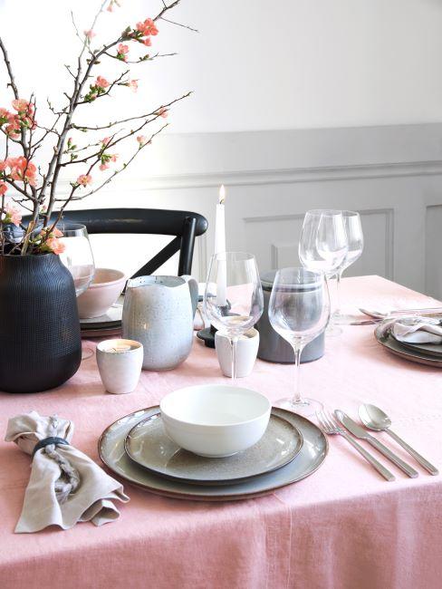 Vaisselle en céramique Table dressée avec nappe rose, vaisselle en céramique et bouquet dans un vase