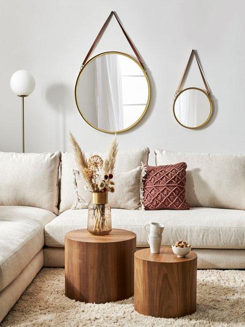 Hygge10 Homestories zandkleurige hoekbank met hoogpolig vloerkleed met ronde houten salontafels en ronde spiegels aan de muur