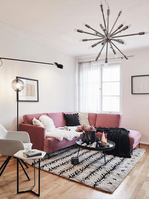 Różowa sofa narożna w małym salonie