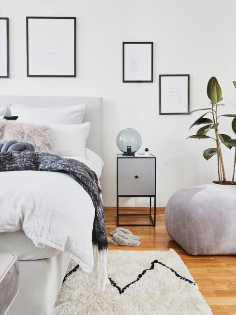 Schlafzimmer in natürlichen Farben mit Bildenrrahmen an der Wand
