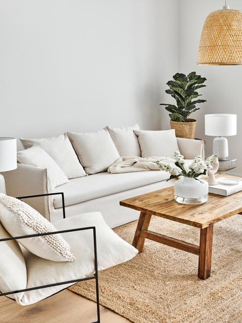 sofa-mila-banner Sofá Mila en tono crema en un salón etno con mesa baja de madera, alfombra de ratán, planta y lámpara de mimbre
