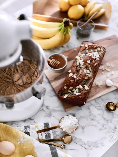 chlebek bananowy na drewnianej desce przy białym robocie kitchenaid