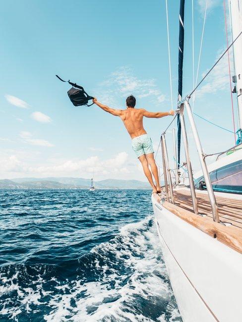 Alleen-op-vakantie-boot-man Oceaan witte boot man met tas