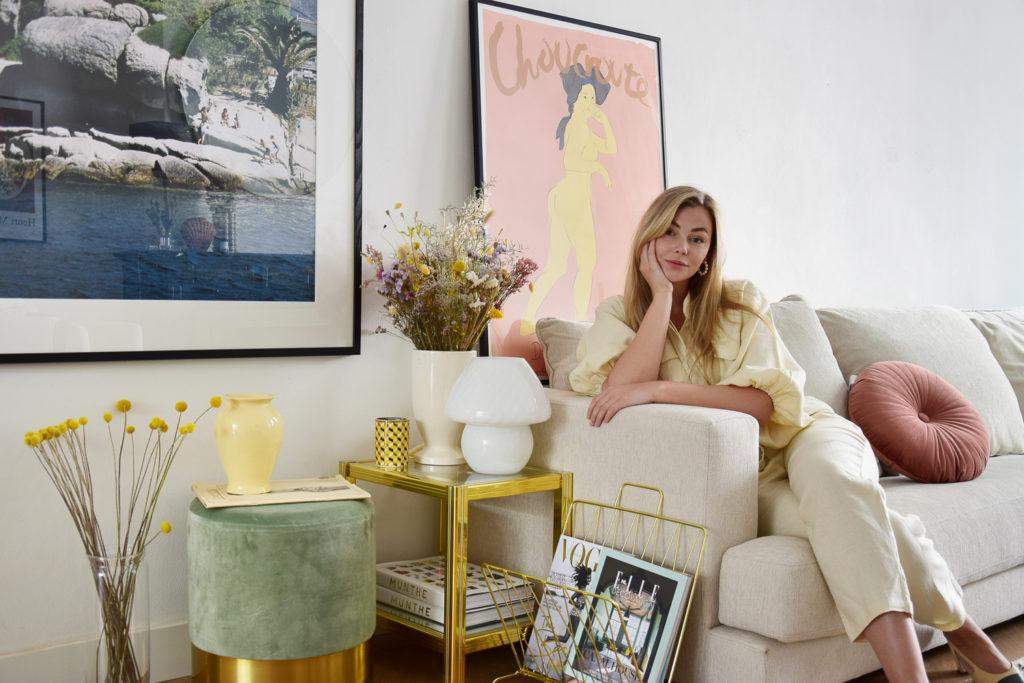 Vivian Hoorn op Creme hoekbank met pastelkleur accessoires en kussens