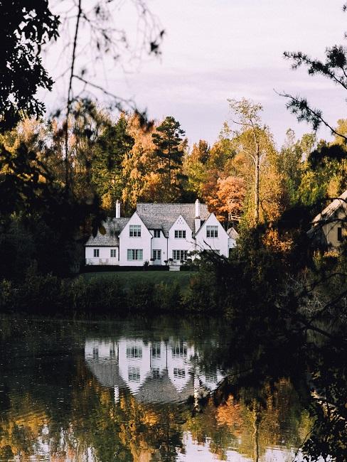 Haus Ideen Ein großes Haus an einem See von Wäldern umgeben.