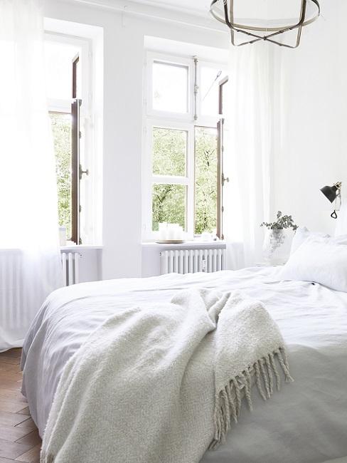 Helles Schlafzimmer mit zwei geöffneten Fenstern