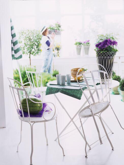 plantes-et-fleurs salon tres clair avec table et chaises blanches, des fleurs disposees partout