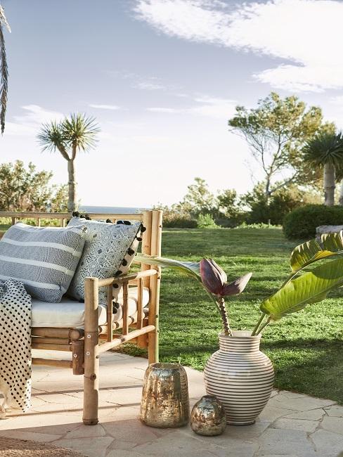 Tropische tuin header Tropische header met bamboe tuinstoel met planten in pot voor grasveld