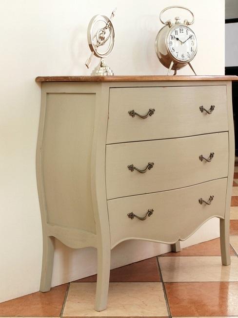 Beige ladekast met zilveren klok