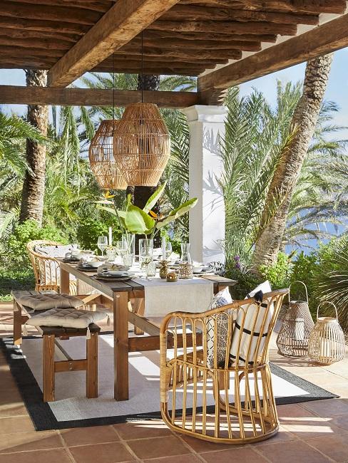 Tuin inspiratie Header Bohemian tuin inspiratie lange houten tafle met bamboe stoel en lamp met witte lakes en details