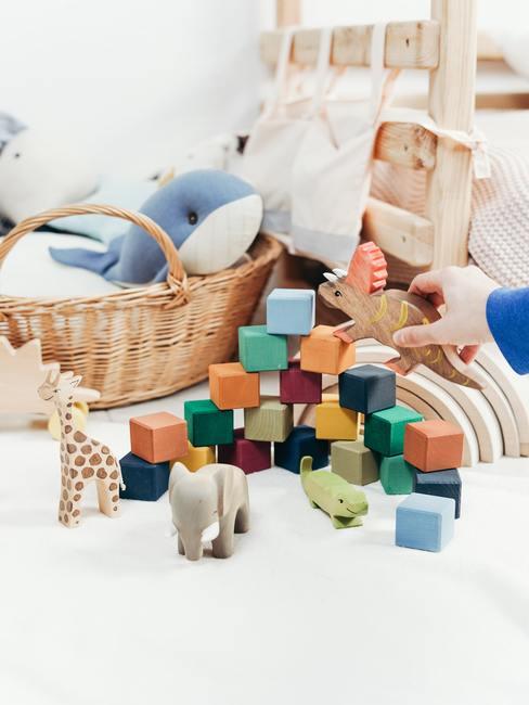 Babykamer hout-1 Houten speelgoed in een kinderkamer op een wit vloerkleed