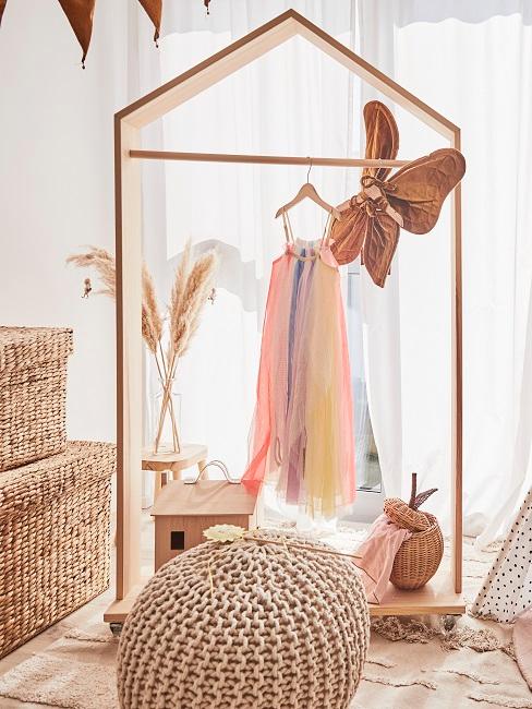 skandinavische deko Kleiderständer aus Holz in einem Kinderzimmer, Pampasgras und Rattanboxen sowie ein Jute Pouf als Deko