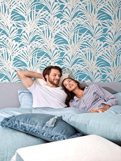 Päärchen im Bett mit hellblauer Bettwäsche