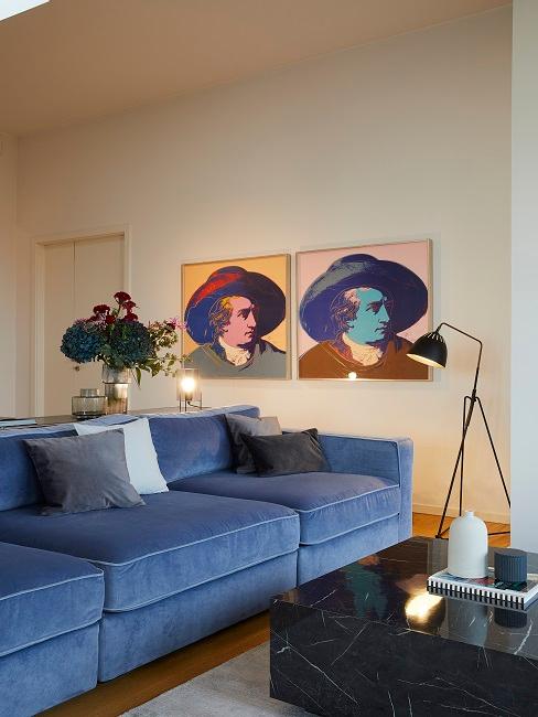 Zwei Wandbilder in modernem Wohnzimmer mit blauer Couch