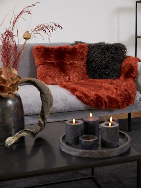 Rot und schwarze Fellkissen auf grauer Couch