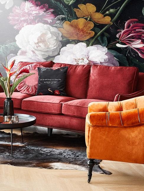 Buntes Wohnzimmer mit Sofa und Sessel vor Blumentapete