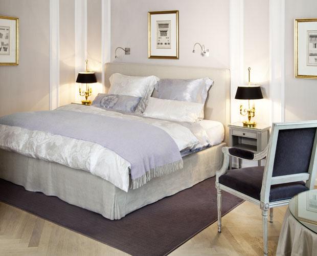 Schlafzimmer mit gemachtem Bett in Weiß und Grau