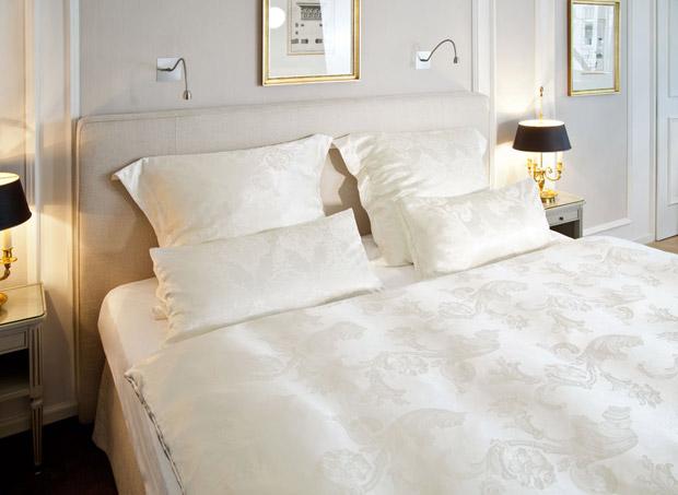 Bett mit Bettwäsche in Weiß