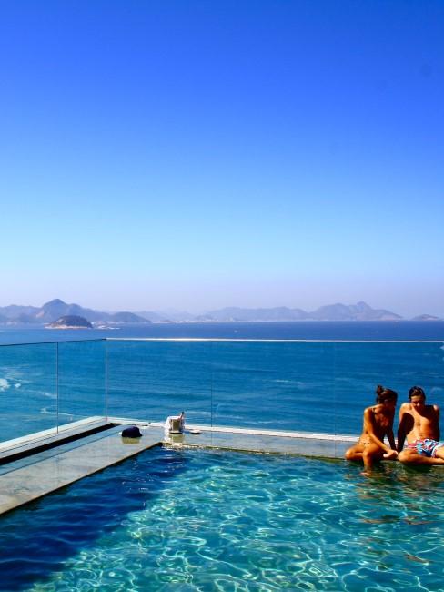 hoteles-romanticos-banner pareja en piscina con mar detras