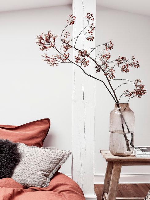 Japanse bloermsierkunst header Japanse bloemsierkunst bloesem in glazen vaas op houten nachtkastje naast bed