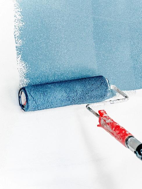 Wandfarbe trocknen Banner Farbroller streicht blaue Wandfarbe an weiße Wand