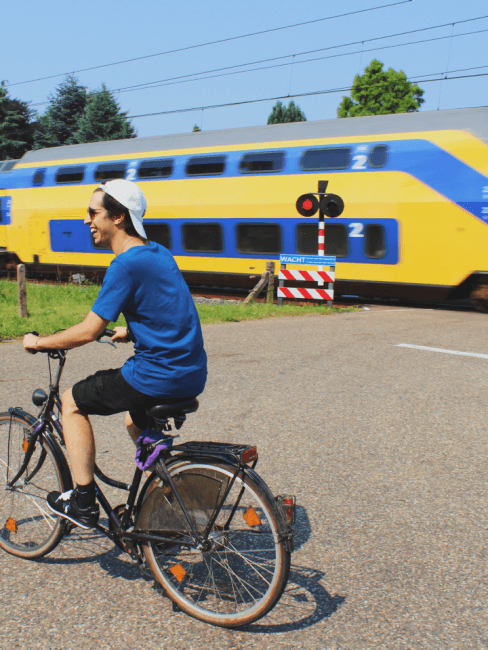 cicloturismo-banner Chico en bici viajando y tren de fondo