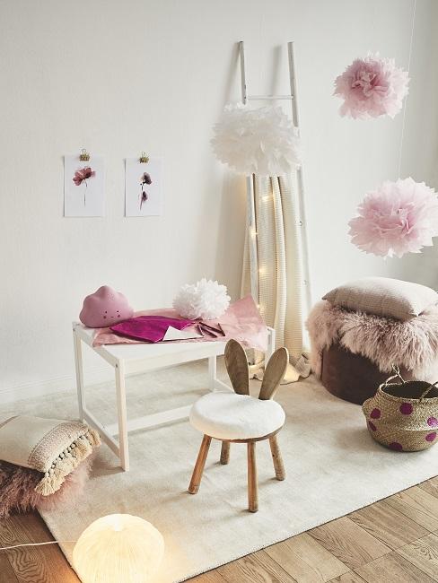Weißer Kindertisch auf Teppich neben Hasen-Stuhl und Wolkendeko