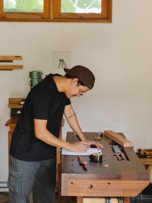 Mann arbeitet an einem Holztisch