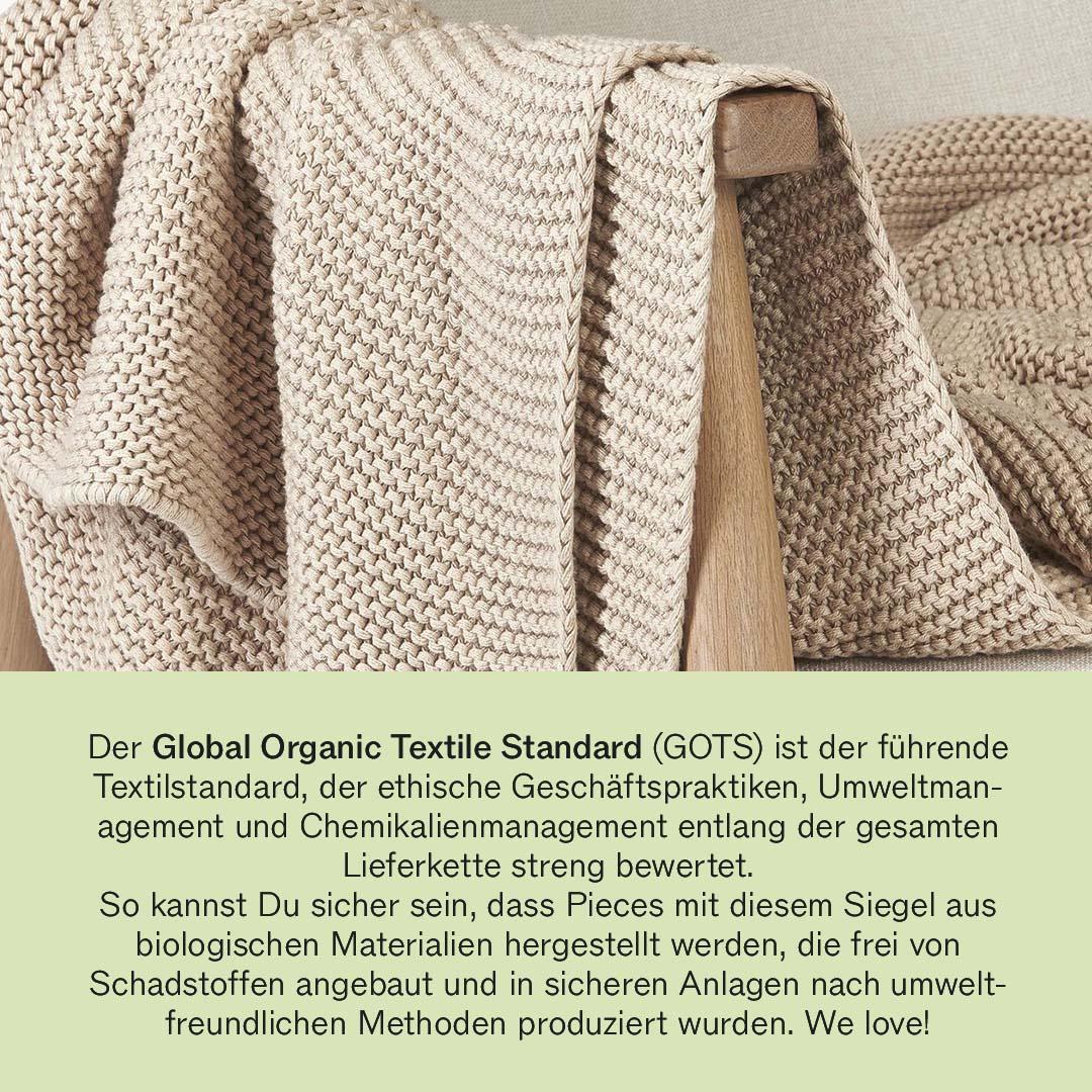 Eine Strickdecke in Beige mit GOTS