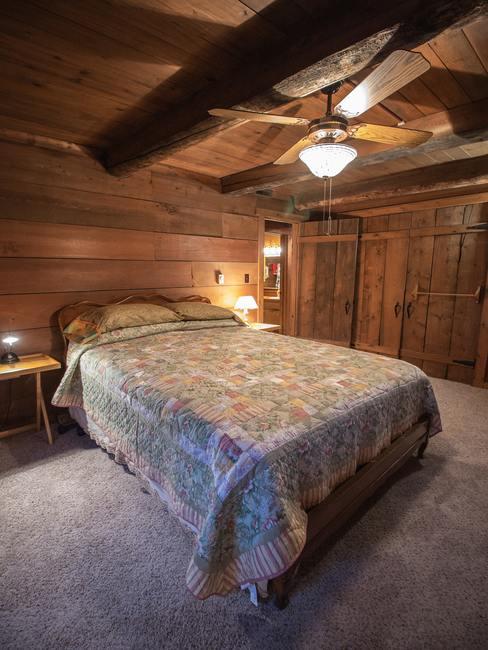 Dormitorio de estilo campestre con techos de madera de color marrón