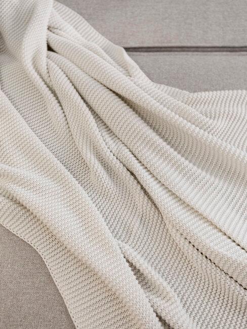 manta blanca sobre sofá beige
