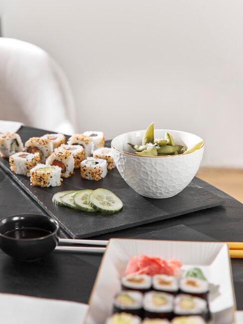 bowl con edamame y platos de sushi