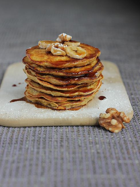 une pile de banana pancakes dressée sur une planche