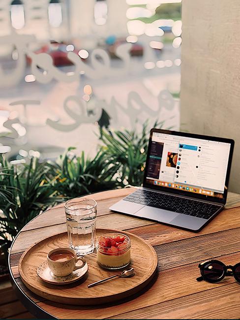 intérieur café avec table en bois, ordinateur portable et plateau rond avec café