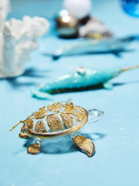 tortue en verre décorative avec écaille texturée dorée sur table bleue