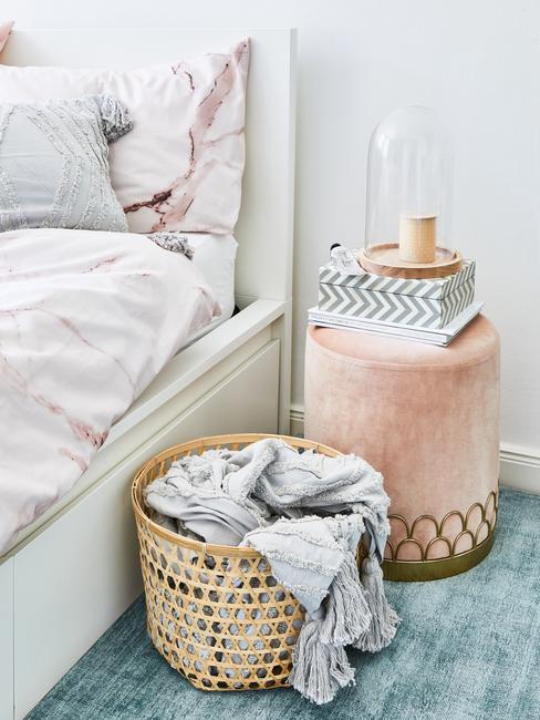 Lit avec panier à linge en osier et table de nuit en veours rose et détails or