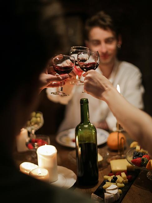 Des personnes entrain de trinquer avec des verres de vin rouge