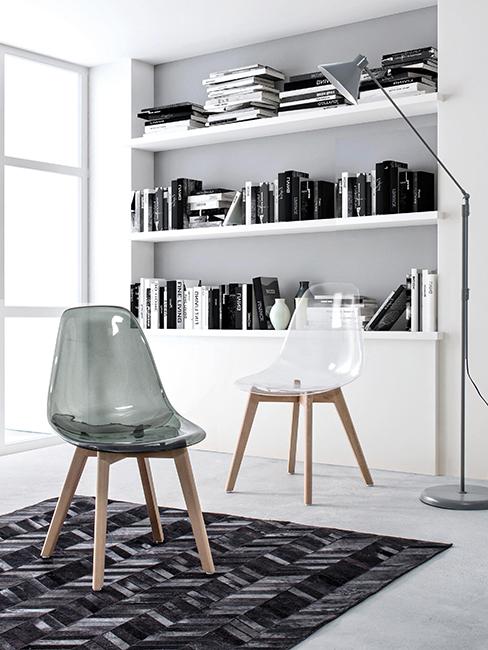 deux chaises en plexiglas devant une binliothèque