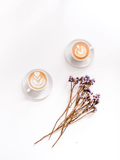 vue du haut sur deux tasses de café au lait avec fleurs séchées posés à côté