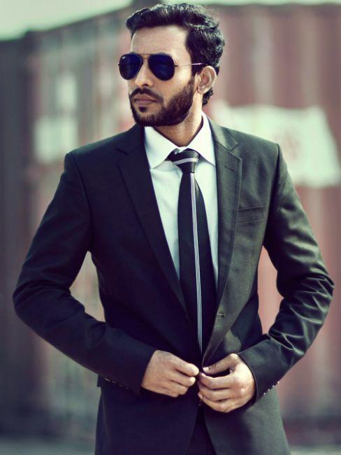 jeune homme en costume avec lunettes de soleil