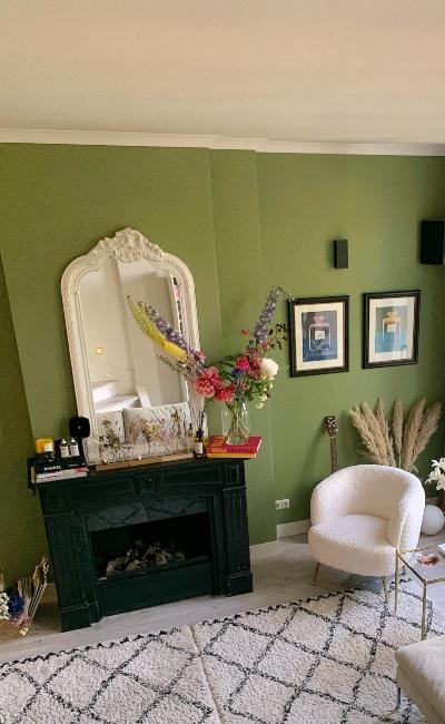 Miroir blanc baroque posé sur cheminée noire