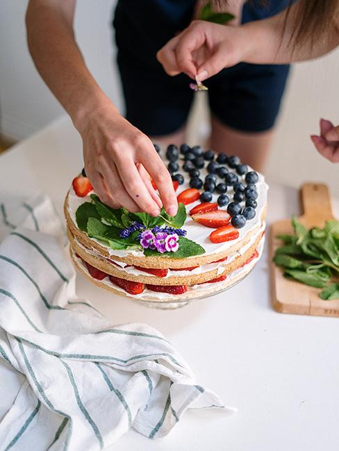 Personne entrain de préparer un gâteau avec des fruits frais