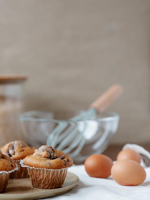 muffins posée sur une table avec des oeufs et un saladier