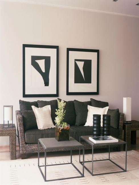 salon moderne, canapé noir en cannage, deux tables basses jumelles, deux grands cadres noir et blanc sur le mur