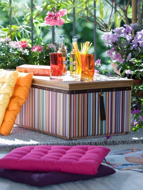 grande boite en guise d une table de fete, coussin de sol, verres a cocktail avec des pailles, fete a l exterieur