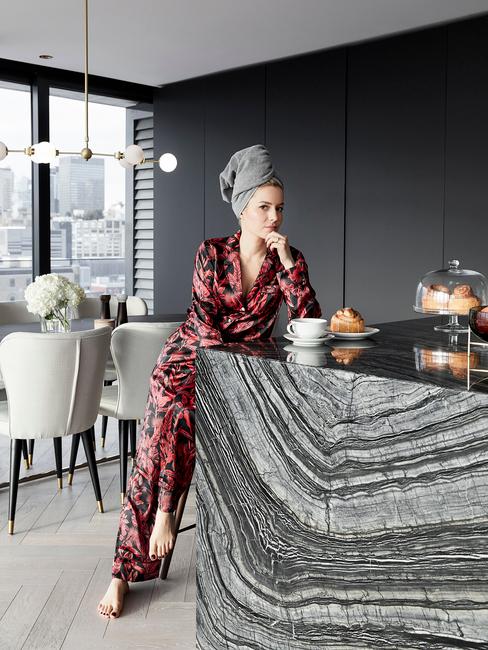 plan de travail de cuisine en marbre gris et femme en pyjama satin rouge